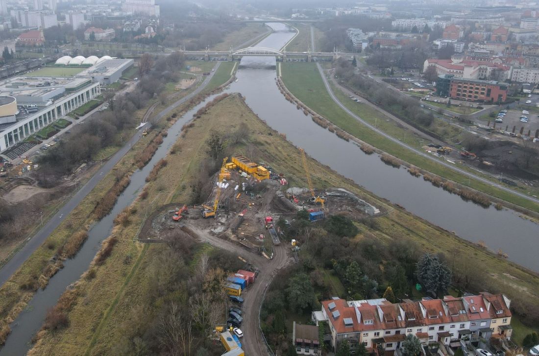 Teren budowy na cyplu międzye Wartą a Cybiną, po lwej stronie budynku Politechniki Poznańskiej, po prawej zabudowania na Starym MIeści, na wprost widoczny most Rocha - grafika artykułu