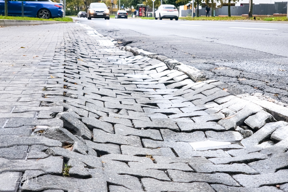 fragment zapadniętej nawierzchni z kostki brukowej w zatoce autobusowej na przystanku