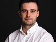 mężczyzna w wieku około 30 lat, ciemne, krótkie włosy, biała koszula