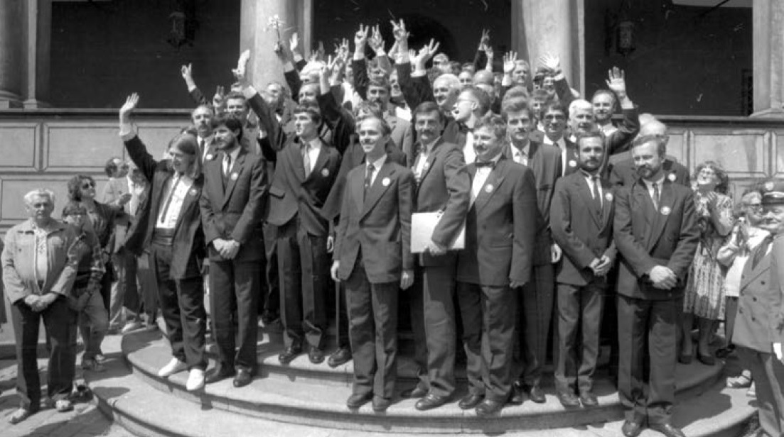 Radni zgromadzeni na stopniach ratusza pozdrawiają mieszkańców Poznania, 2 czerwca 1990 r., fot. R. Świątkowski (źródło: Kronika Miasta Poznania 2/2016 "Samorządowa rewolucja 1990") - grafika artykułu