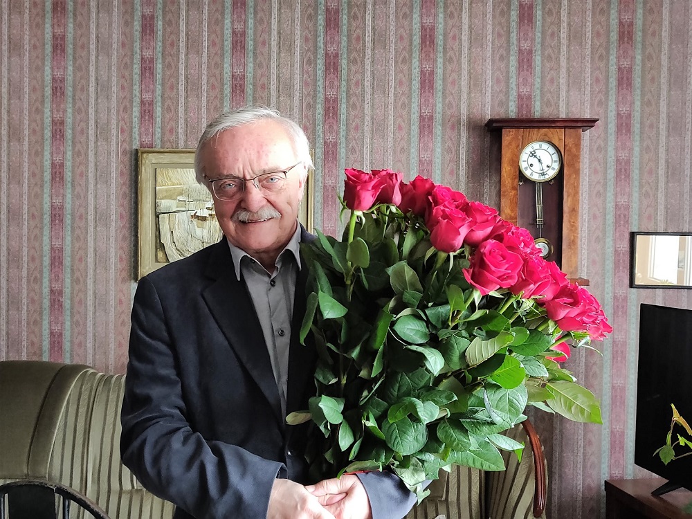 Prof. Antoni Szczuciński z bukietem 43 róż symbolizujących 43 lata pracy na Wydziale Filozoficznym Uniwersytetu im. Adama Mickiewicza (fot. Wydział Filozoficzny UAM) - grafika artykułu