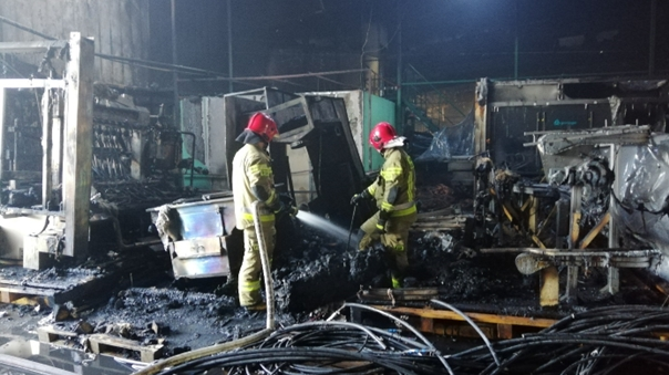 Strażacy dogaszają i kontrolują spaloną halę magazynową