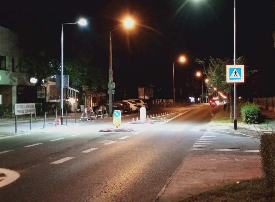 Jezdnia w porze nocnej, przejście dla pieszych oświetlone ulicznymi latarniami - grafika artykułu