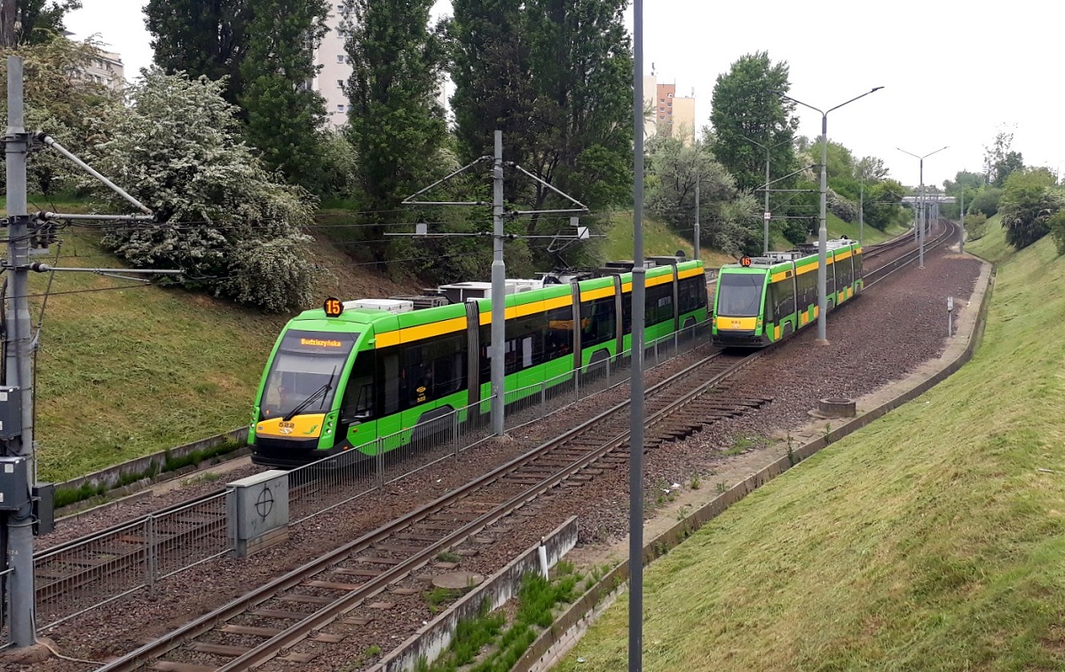 Dwa mijające się tramwaje na torowisku proprowadzonym w wykopie porośniętym trawą - grafika artykułu