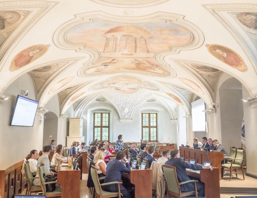 Radne i radni obradują w sali sesyjnej, widoczne sklepienie sali z barwnymi, zabytkowymi malowidłami - grafika artykułu