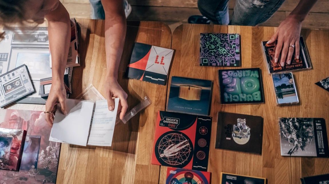 na stole rozłożonych jest około kilkanaście różnych okładek płytowych