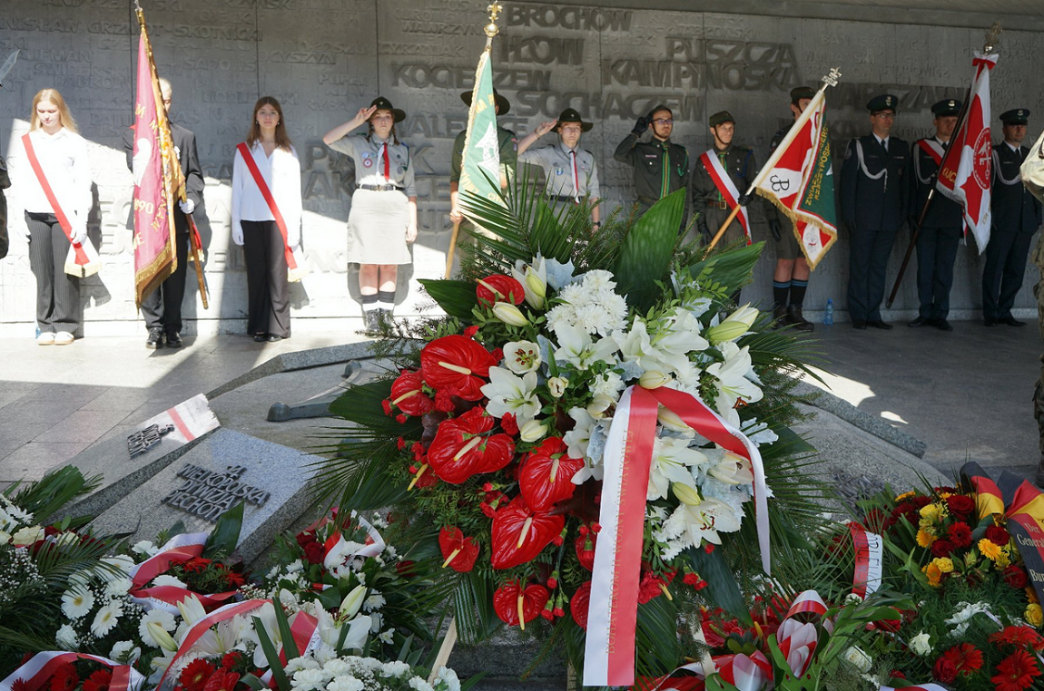 grupa harecerzy zgomadzona przy pomniku, przed nimi wieńce kwiatów - grafika artykułu