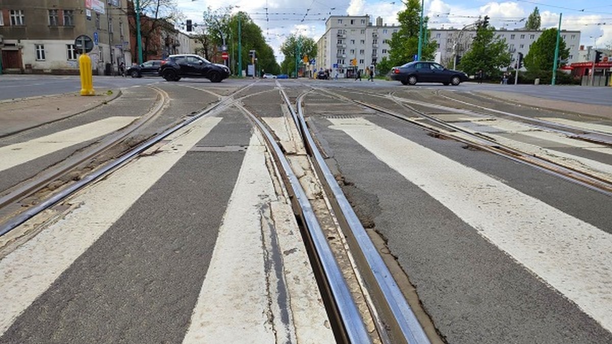 skrzyżowanie ulic i torowisk tramwajowych, widoczne samochody budynki przy skrzyżowaniu - grafika artykułu
