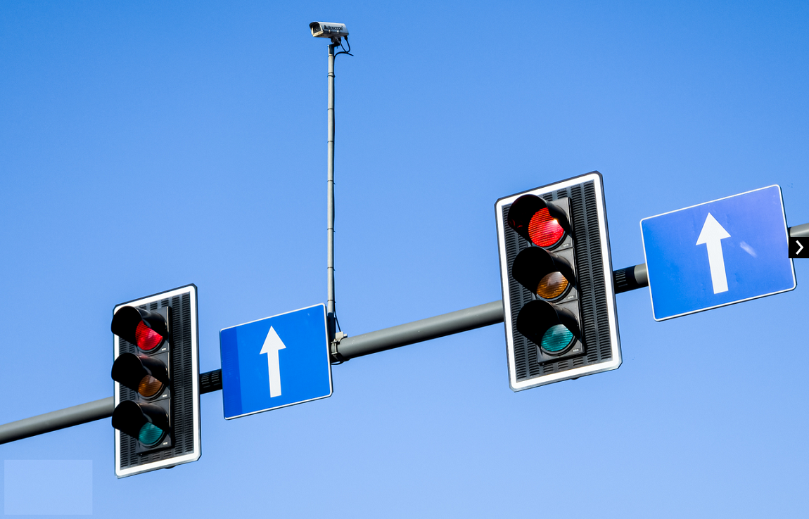 dwa sygnalizatory świetlne zawieszone nad ulicą obo noch znaki drogowe wskazujące kierunek jazdy prosto - grafika artykułu