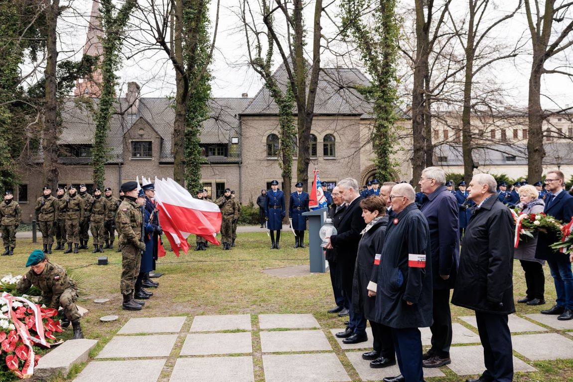 Na zdjęciu delegacja składająca kwiaty pod pomnikiem, w tle asysta wojska i innych mundurowych - grafika artykułu
