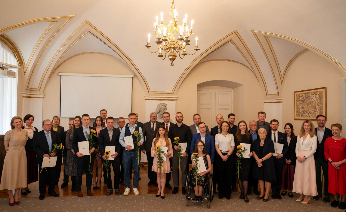 Grupa osób stoi w eleganckim wnętrzu, prawdopodobnie podczas ceremonii wręczenia nagród. - grafika artykułu