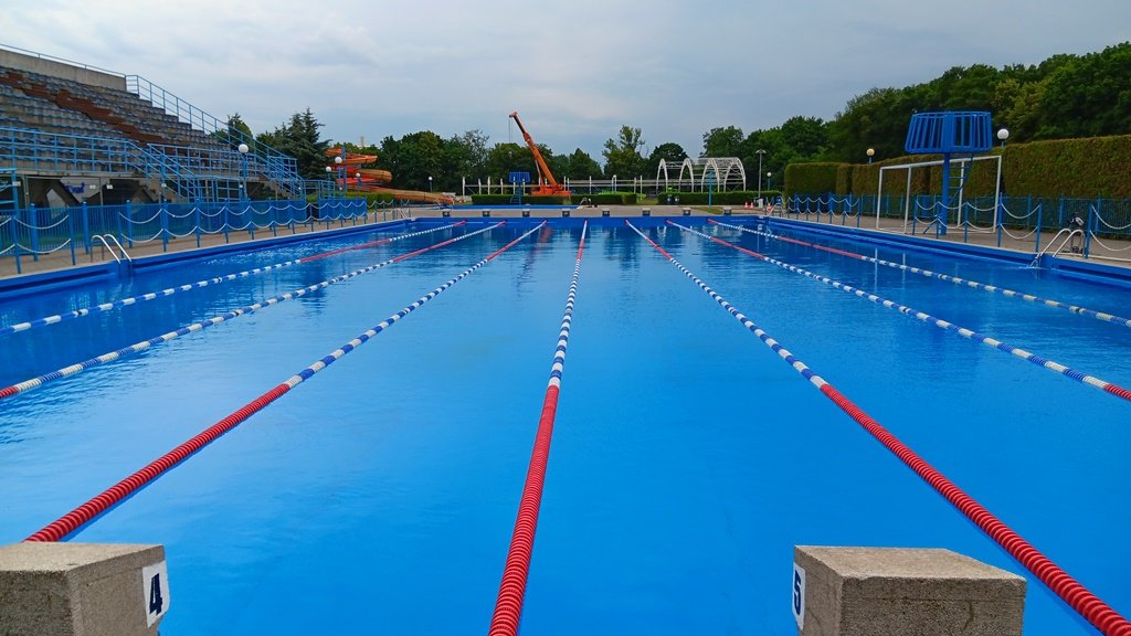 basen odkryty, widoczne tory pływackie, trybuny zielone otoczenie