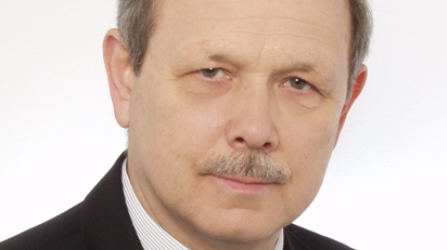 Tomasz Sokołowski - tytuł Zasłużony dla Miasta Poznania 2025 - mężczyzna w średnim wieku, częściowo siwiejące włosy i wąs, ubrany w ciemną marynarkę i jansą koszulę, delikatnie się uśmiecha