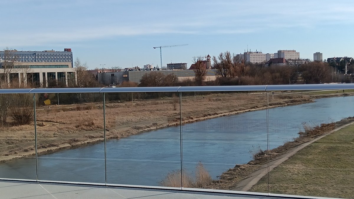 fragment kładki pieszo-rowere z całkowicie przeszklonymi balustradami