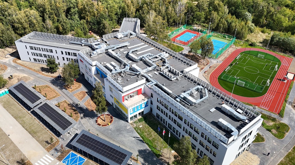 Widok z lotu ptaka na nową szkołę na Strzeszynie, obok szkoły boiska i parking - grafika artykułu