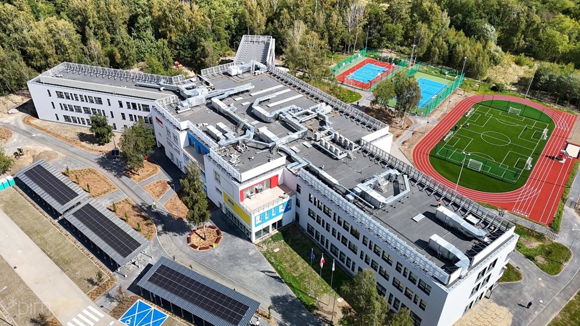 Widok z lotu ptaka na nową szkołę na Strzeszynie, obok szkoły boiska i parking