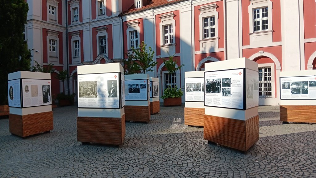 Otwarcie wystawy poświęconej Cyrylowi Ratajskiemu widok na plansze stojące na dziedzińcu Urzędu Miasta
