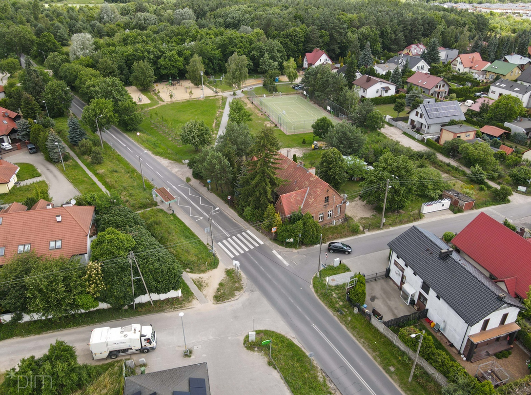 widok z lotu ptaka na skrzyżowanie w zabudowie budynków jednorodzinnych, są też drzewa i trawniki - grafika artykułu