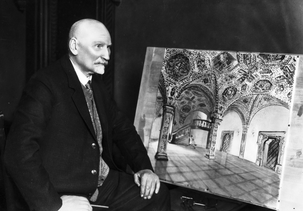 archiwalne czarno białe zdjęcie przestawiające starszego mężczyzne z łysą głową i szpiczastą bródkaubrany w garnitur siedzi bokiem obok niego obraz przedstawiający sale w ratuszu poznańskim - grafika artykułu