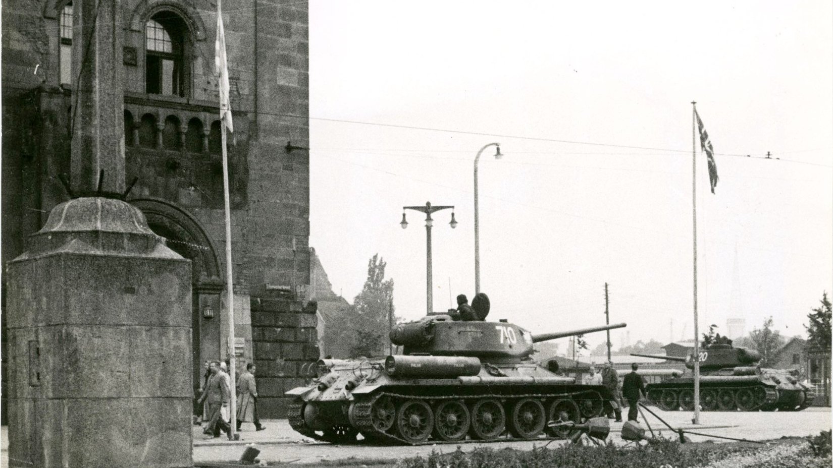 archiwalne zdjęcie przedstawiające czołgi na ulicach w zabudowie śródmiejskiej