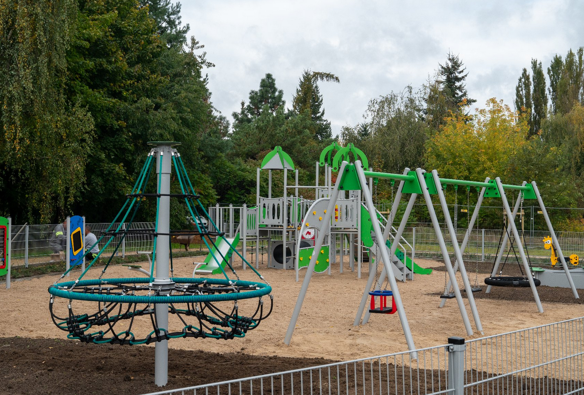 Osiedlowy komplekst sportowo-rekreacyjny z różnymi urządzeniami na piaszczystym podłożu otoczony drzewami - grafika artykułu