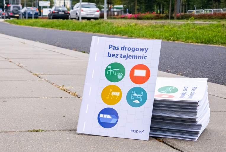 broszury ułożone na chodniku, na okładce tytuł "Pas drogowy bez tajemnic" - grafika artykułu