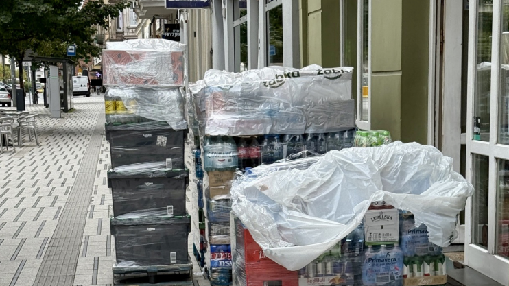 palety z towarem ułożone na chodniku przed sklepem