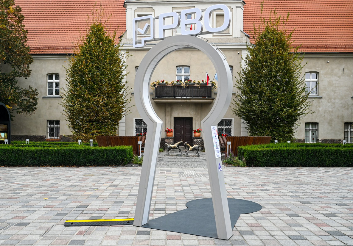 duża instalacja w formie dziurki od klucza z napisem PBO stojąca na dziedzińcu otoczonym kamienicami - grafika artykułu