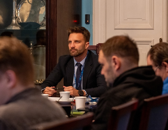 przy stole konferencyjnym obraduje kilkoro osób