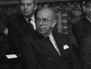 zdjęcie archiwalne starszego mężczyzny w garniturze siedzącego na krześle w kościele, obok niego inni mężczyźni