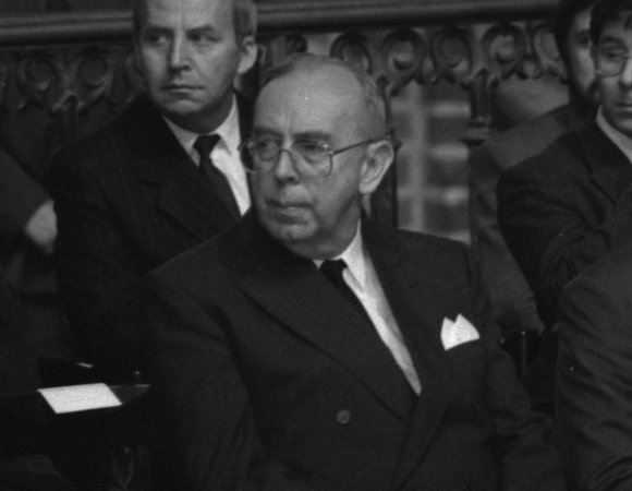 zdjęcie archiwalne starszego mężczyzny w garniturze siedzącego na krześle w kościele, obok niego inni mężczyźni