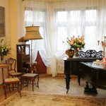 Salon: fortepian, krzesła, lampa