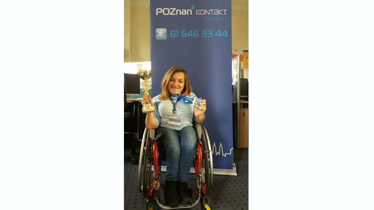 Zdjęcie zwyciężczyni na podium z medalem w dłoniach