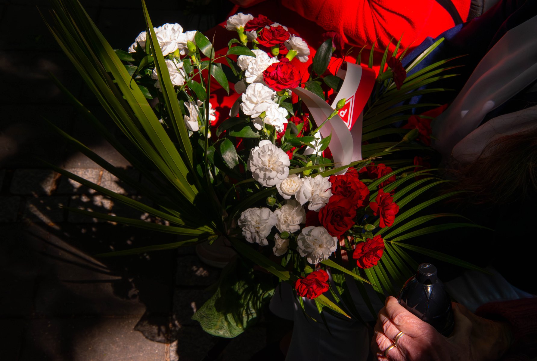 Wolę upamiętnienia żołnierzy drugiej konspiracji w formie pomnika wyraziła Rada Miasta Poznania w 2018 roku Bukiet czerwonych i białych goździków z zielonymi liśćmi, prawdopodobnie trzymany przez starszą osobę.