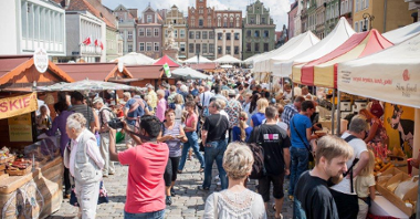Zdjęcie przedstawia Jarmark Dobrego Smaku na Starym Rynku. Widać na nim stoiska handlowe oraz tłumy poznaniaków i turystów