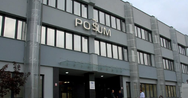 Zdjęcie przedstawia fasadę POSUM, w centrum główne wejście do budynku