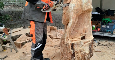 Zdjęcie przedstawia tworzenie rzeźby w drewnie