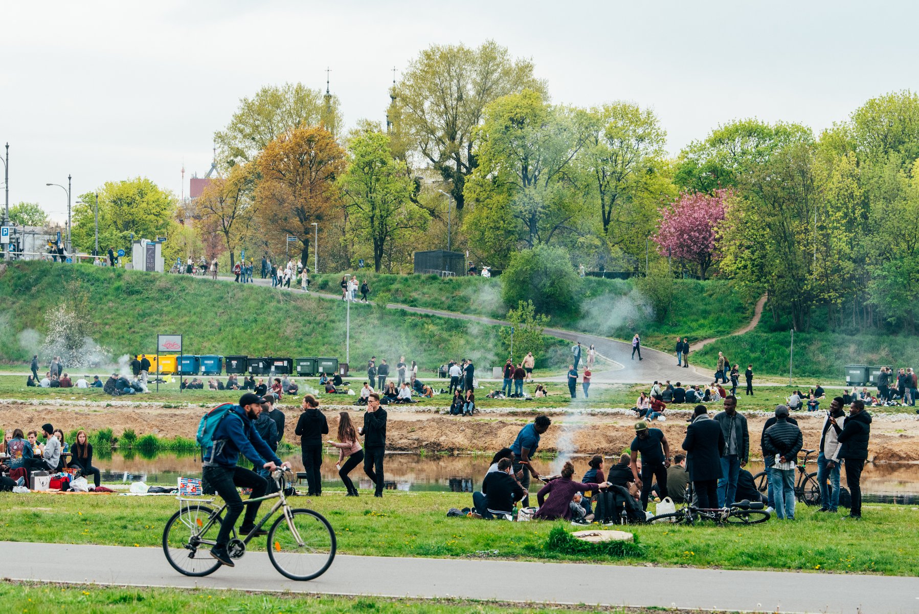 Wartostrada to zielona przestrzeń w centrum miasta, która w ciepłe, wiosenne dni przyciąga tłumy mieszkańców Zdjęcie przedstawia tłum ludzi nad Wartą.