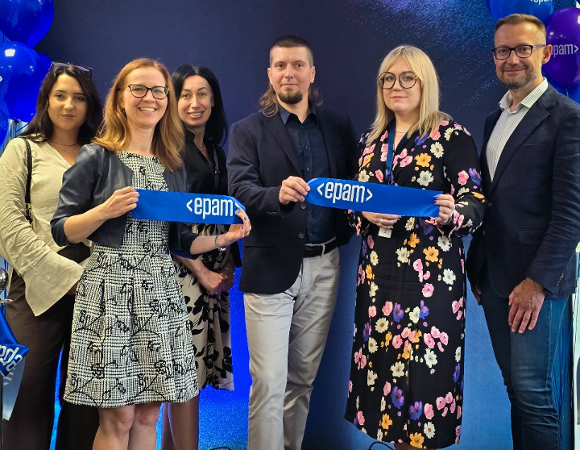 Przedstawiciele Biura Obsługi Inwestorów oraz Firmy EPAM Zdjęcie z wydarzenia. 6 osób na tle ścianki z logo epam. 3 trzymają niebieskie wstązki z logiem firmy