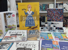 Publications from Poznań on the Book Fairs in Gyor In the photo, there are numerous books displayed behind a counter. They are spread out before the viewer's eyes.