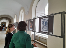 Exhibition at Poznań City Hall In the photo we see two women standing with their backs looking at the exhibition