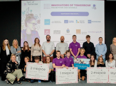 Winners of the Innovators of Tomorrow project The photo shows a dozen people against a screen, all posing for a photo
