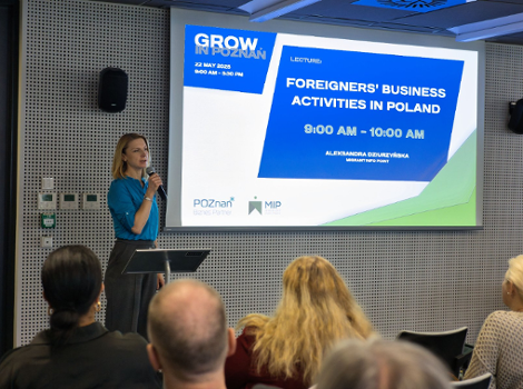 Grow in Poznan - a lecture by Aleksandra Dziurzyńska about starting a business in Poland. The speaker is giving a lecture at the conference. Participants can be seen seated, and a multimedia presentation is being displayed.