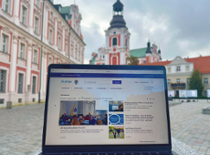 Fot. Biuro Rady Miasta otwarty lapto z wyświetloną stroną Rady Miasta Poznania w tle plac kolegiacki i gmach Urzędu Miasta Poznania - grafika artykułu