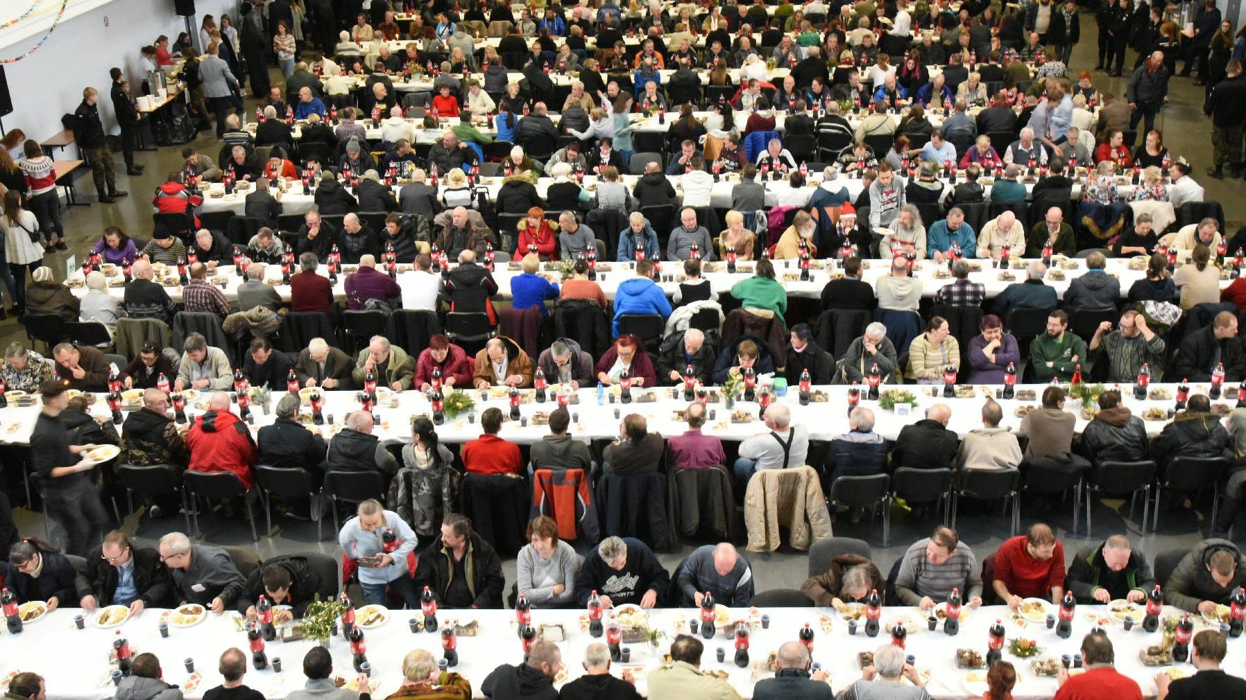 Zdjęcie przedstawia spotkanie wigilijne na MTP. Widok z góry na rzędy stołów, przy któych siedzą ludzie - grafika artykułu