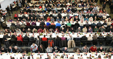 Zdjęcie przedstawia spotkanie wigilijne na MTP. Widok z góry na rzędy stołów, przy któych siedzą ludzie