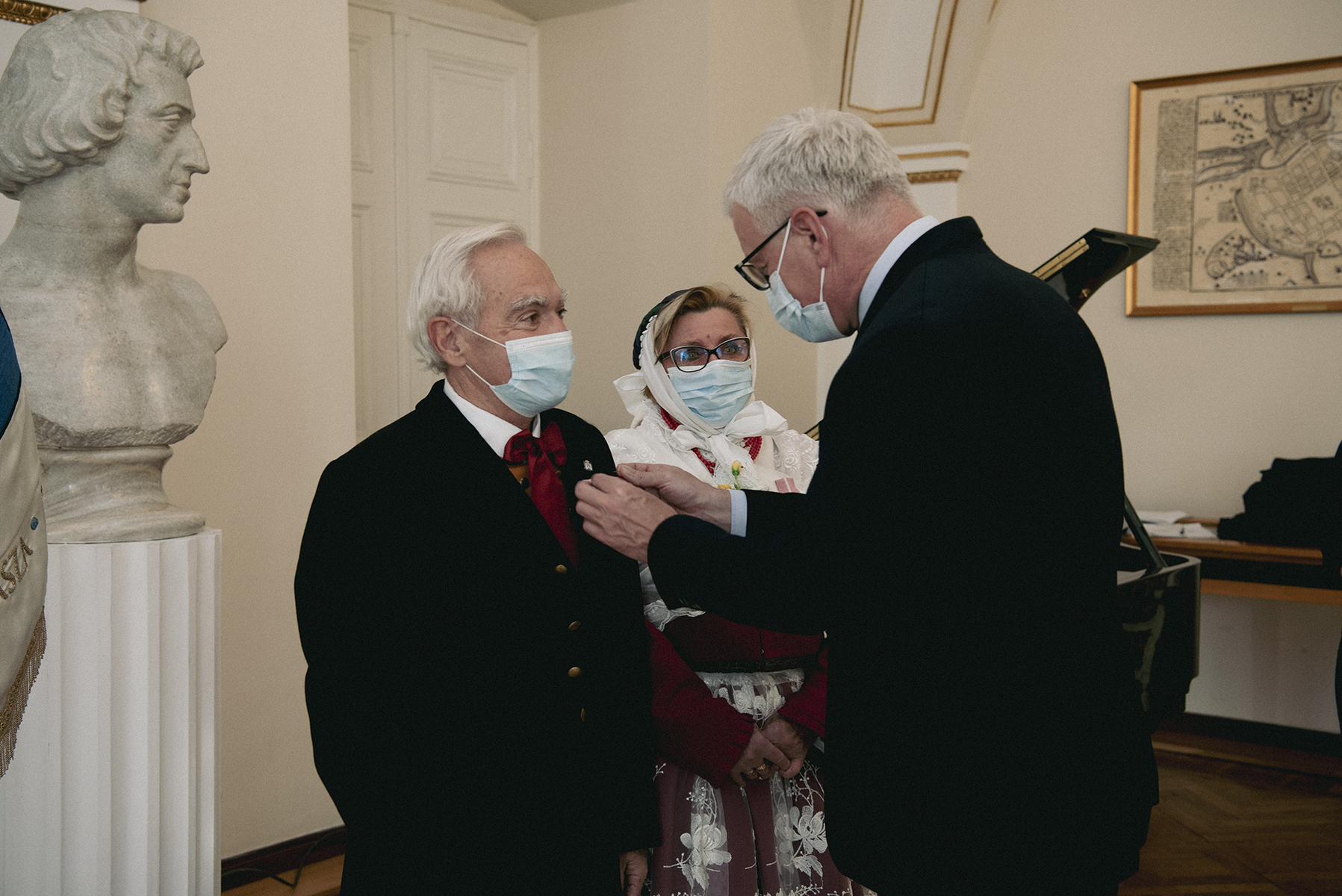 Jacek Jaśkowiak, prezydent Poznania, przypina medale parze ubranej w tradycyjne stroje Bambrów - grafika artykułu