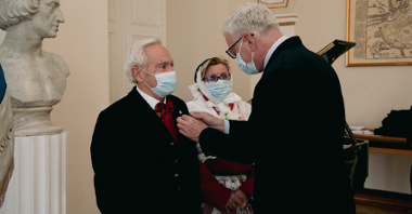 Jacek Jaśkowiak, prezydent Poznania, przypina medale parze ubranej w tradycyjne stroje Bambrów