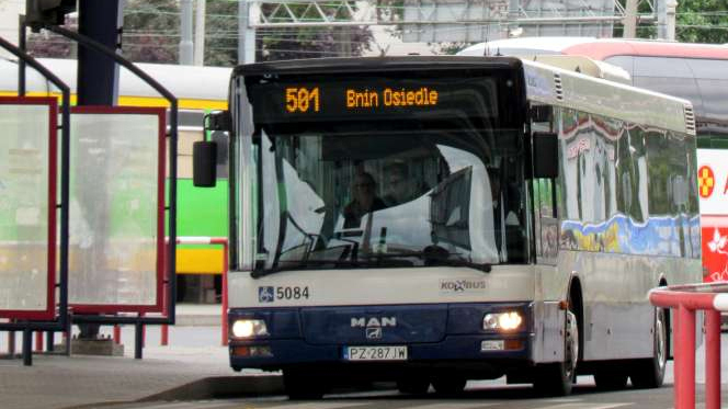 Dworzec autobusowy i biało-niebieski autobus komunikacji zbiorowej
