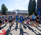 Bieg Czerwca '56 w 2024 roku, fot. Tomasz Szwajkowski - tłum ludzi na starcie w strojach sportowych, niektórzy z flagami, a z boku stoją kibice